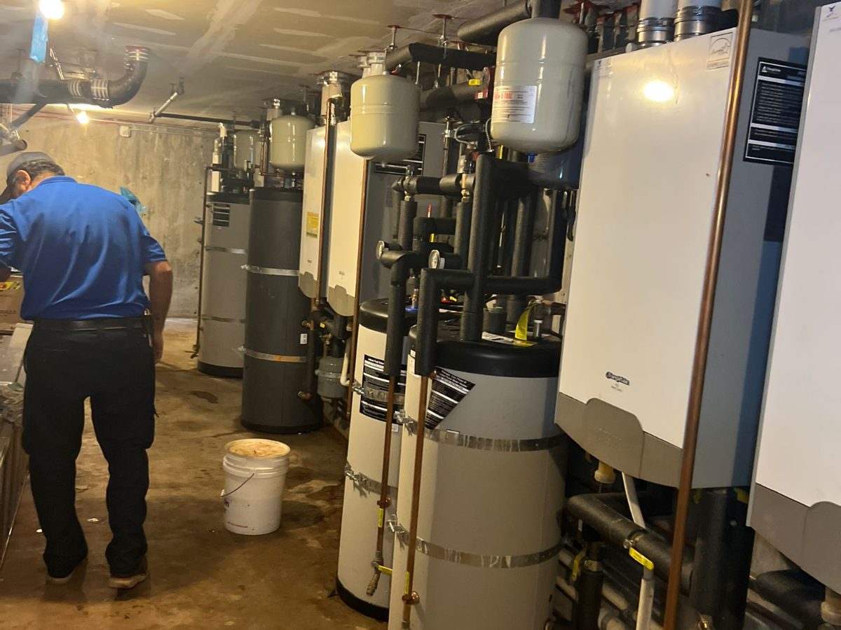 Apex technician servicing a commercial boiler and water heater room