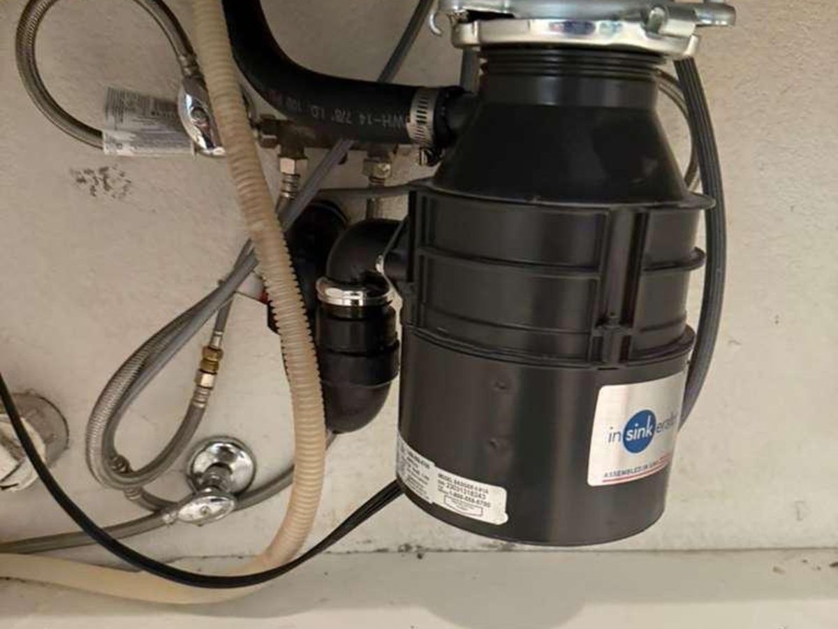 New garbage disposal installed under a kitchen sink