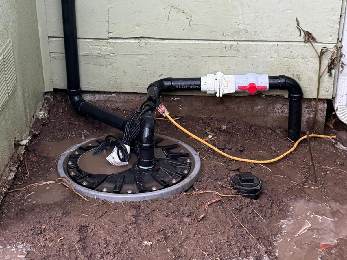 Sump pump installed in a basin with new PVC discharge piping